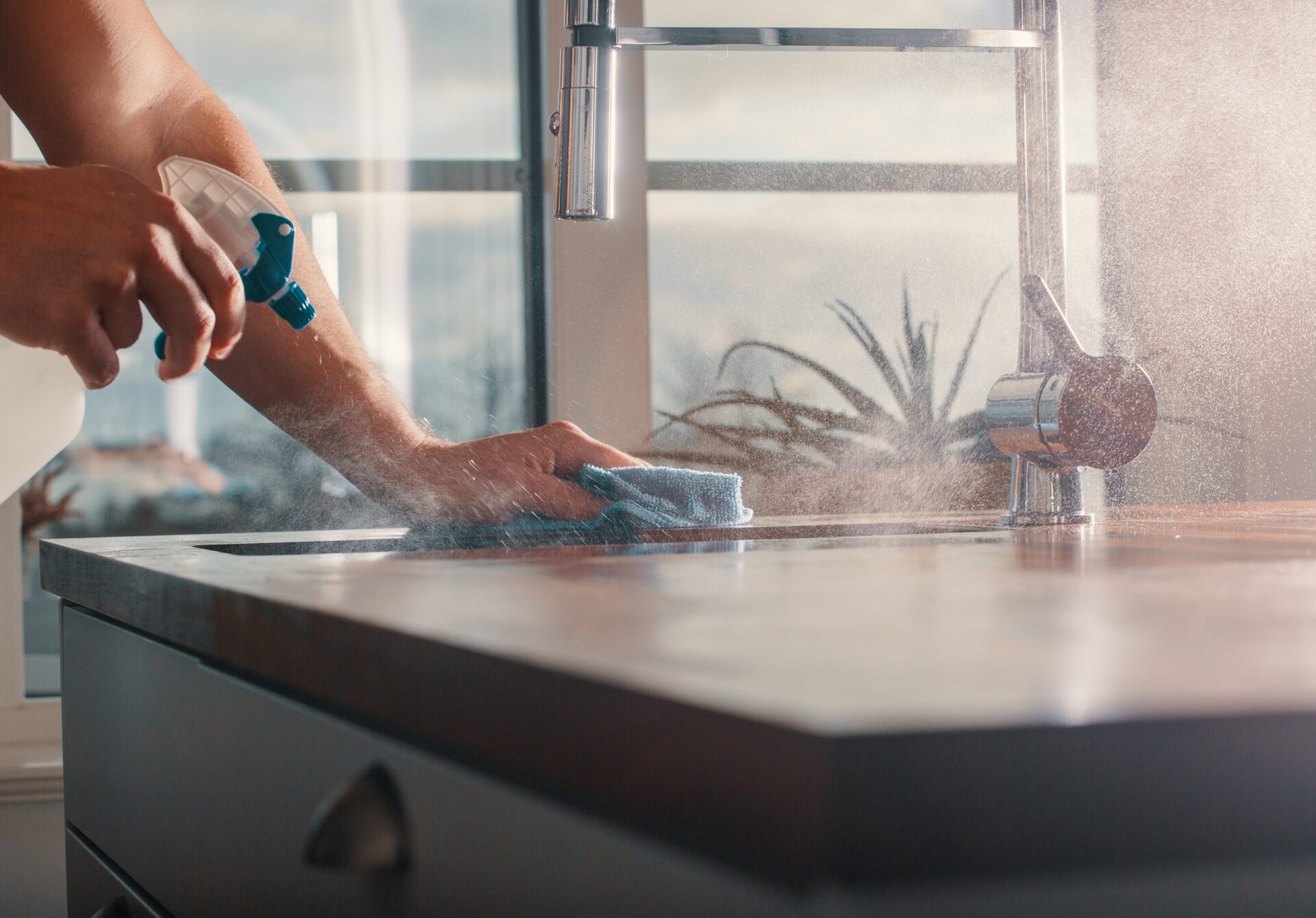 Hands wiping down a kitchen counter